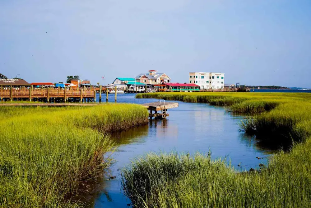 The Southport waterfront and boardwalk seen across the marsh creek